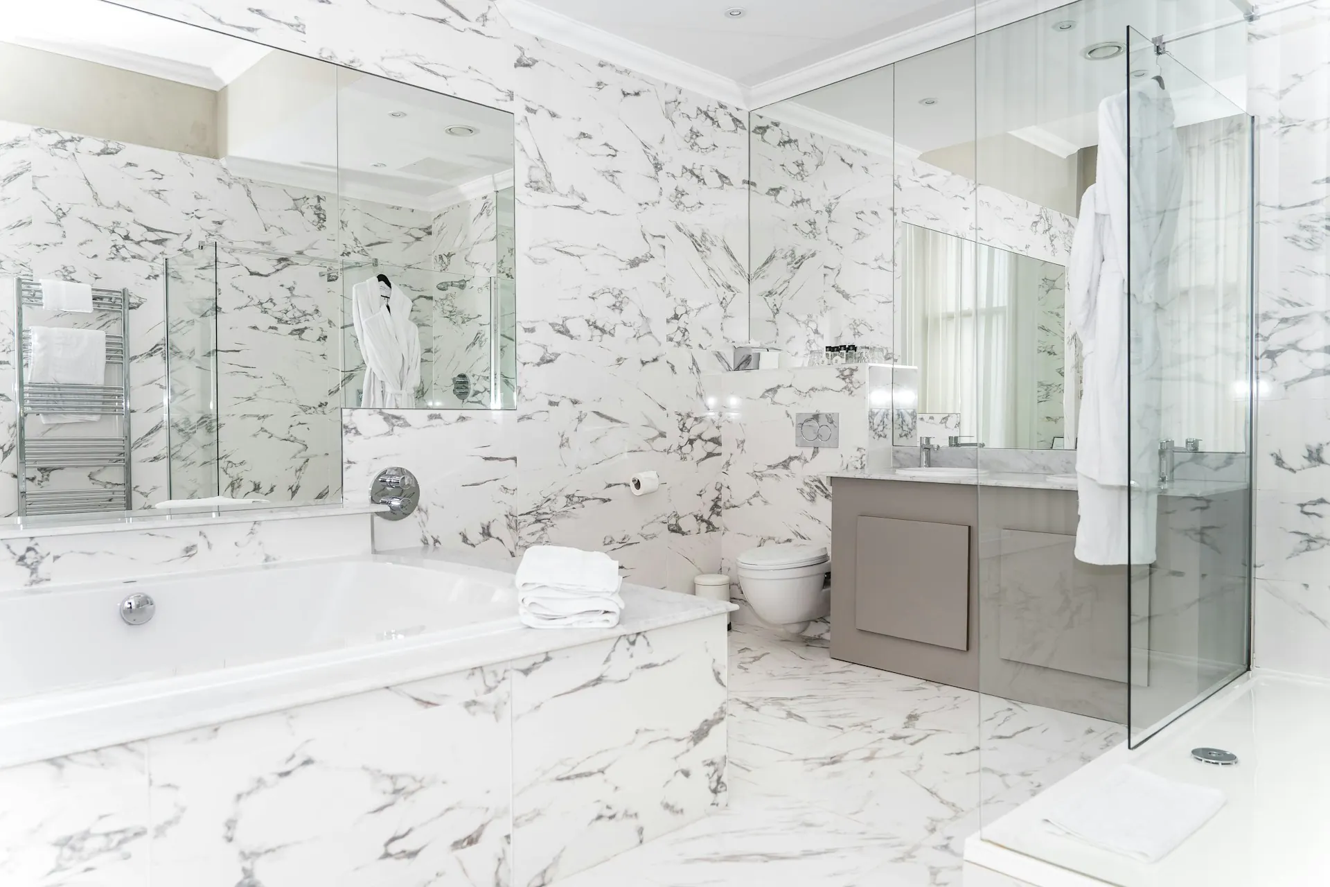 Luxurious primary bathroom remodel in Paramus NJ — freestanding tub, marble vanity, walk-in shower glass